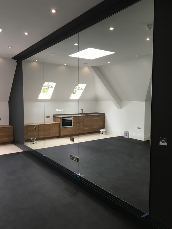 Frameless glass partition in loft conversion by Neasden glaziers