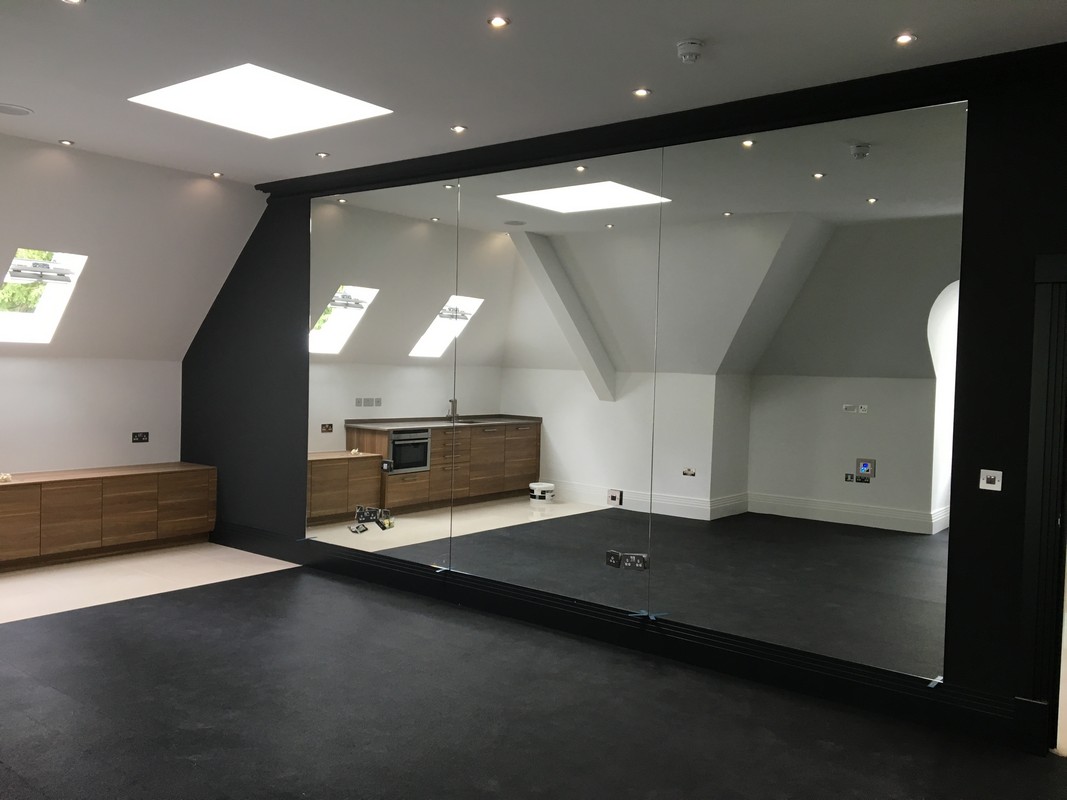 Frameless glass wall dividing loft conversion in Neasden